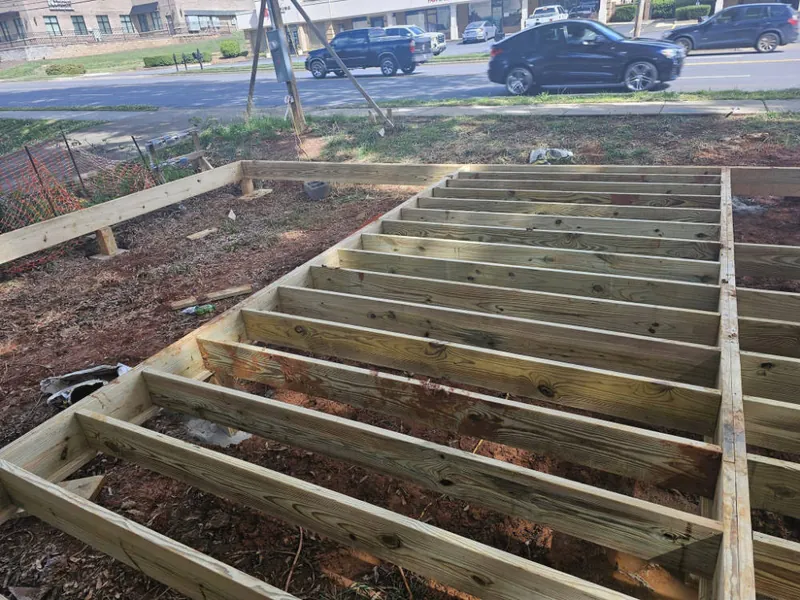 Pressure-treated deck joists framed on footings beside a residential street
