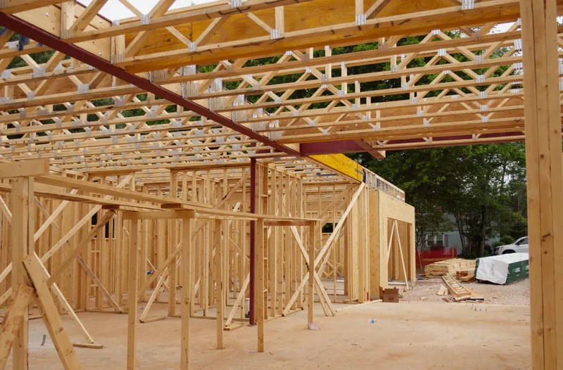 Long framed wall and roof trusses of a building under construction, seen from inside