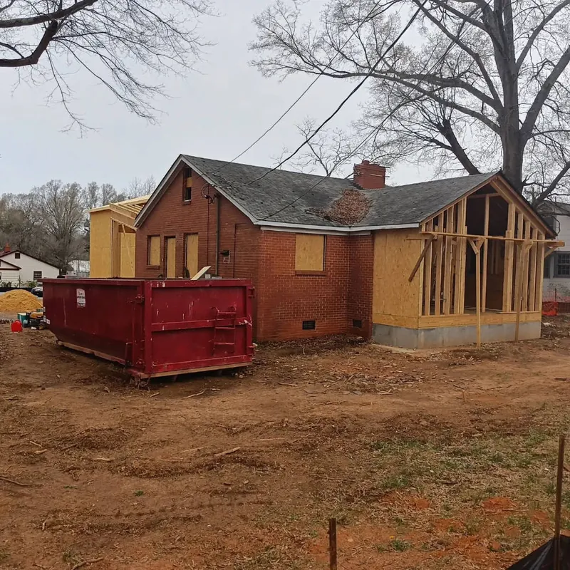 New framed addition rising behind the original brick house during the Panzu Brewery renovation in Mint Hill