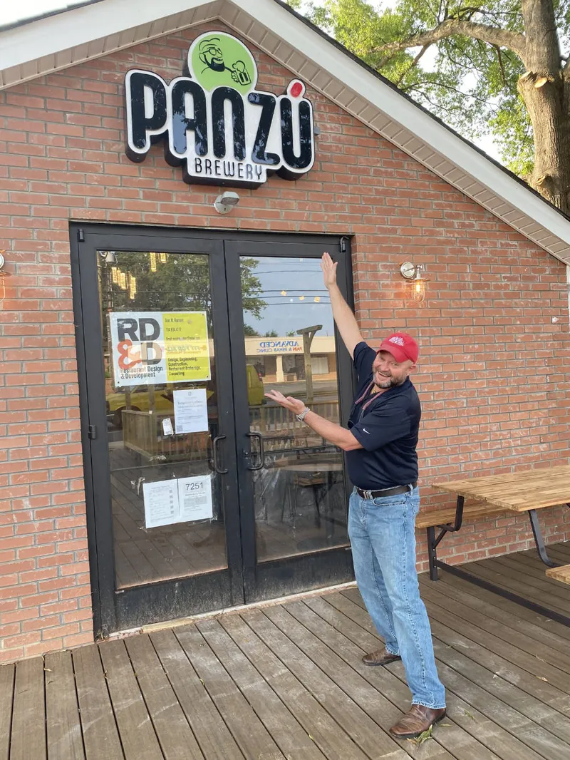 Man at the front door of the renovated brick Panzu Brewery building in Mint Hill